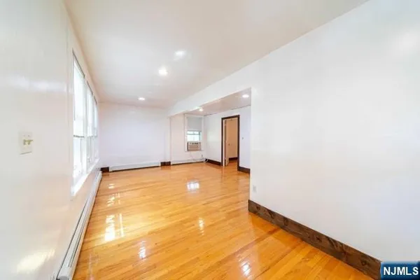 a view of empty room with wooden floor