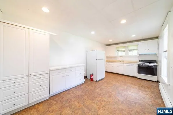 a view of a kitchen with refrigerator and cabinet
