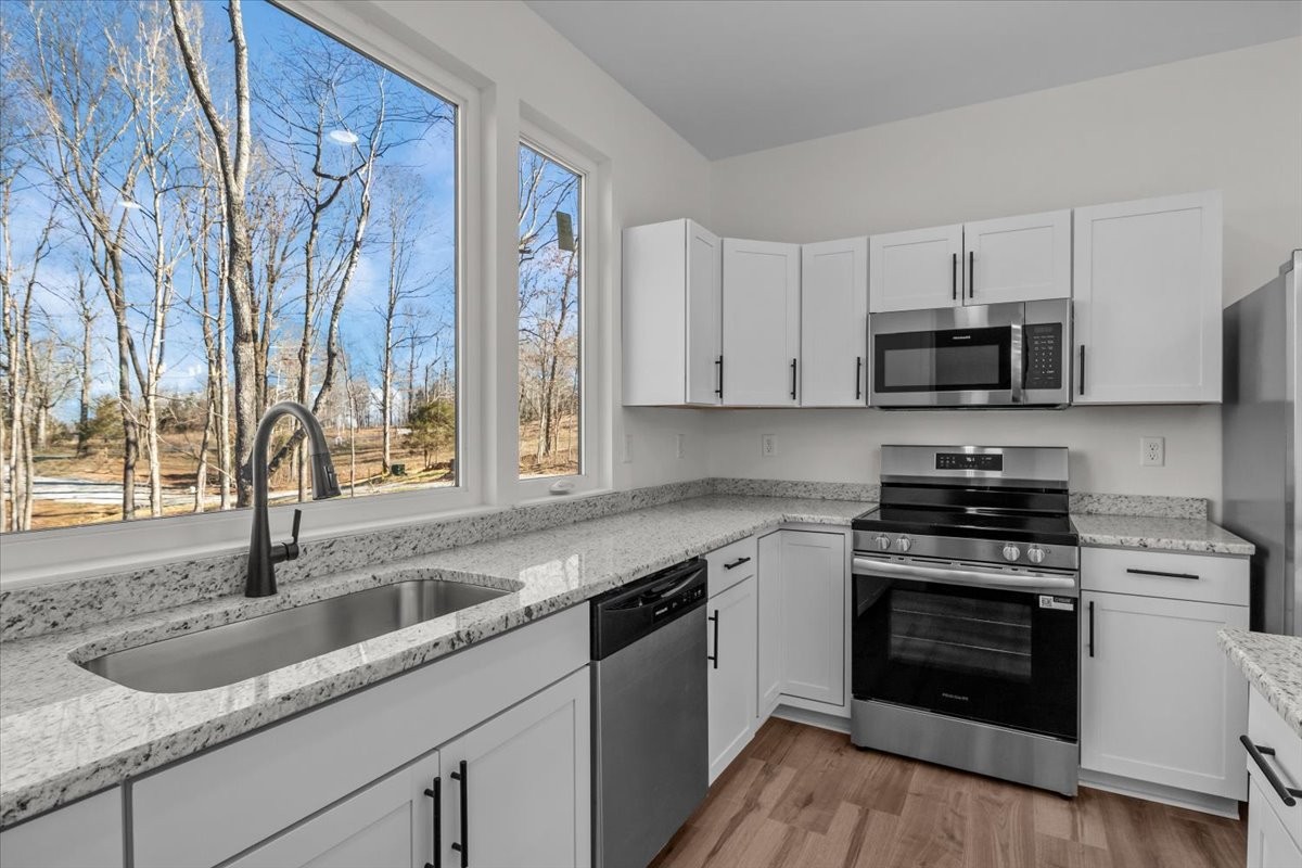 1050 Promise Land Road Charlotte, TN 37036 - Photo 9 of 29 a kitchen with stainless steel appliances granite countertop a sink and a stove