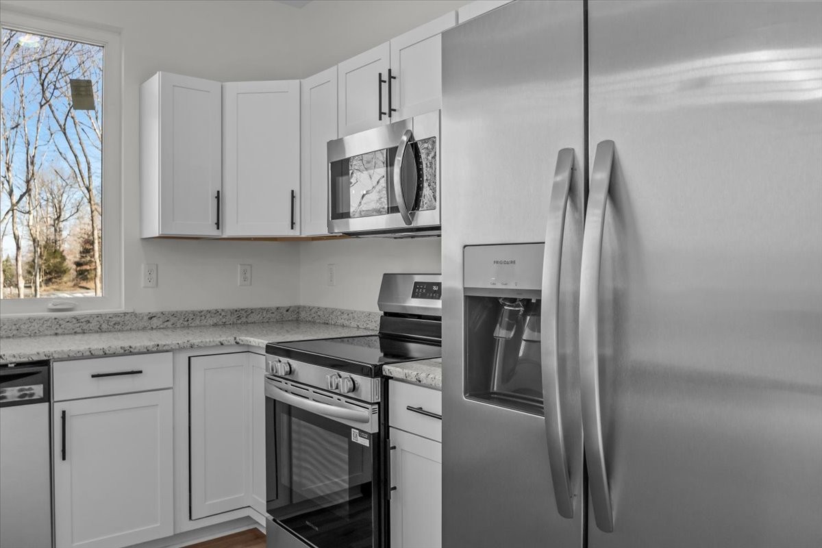 1050 Promise Land Road Charlotte, TN 37036 - Photo 10 of 29 a kitchen with stainless steel appliances granite countertop a refrigerator and a stove top oven