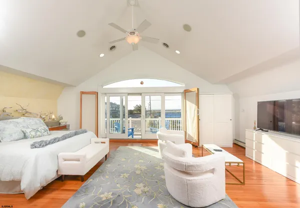 a spacious bedroom with a large bed and a flat screen tv