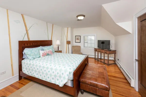 a bed sitting in a spacious bedroom next to a window