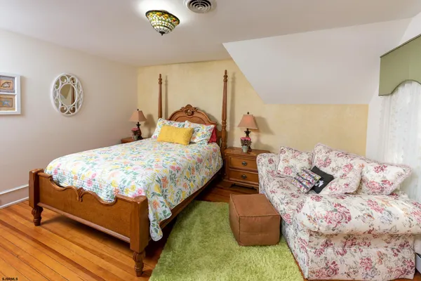 a bedroom with a bed and a lamp on dresser