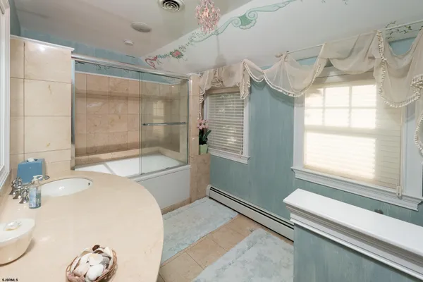 a bathroom with a granite countertop sink and a bathtub