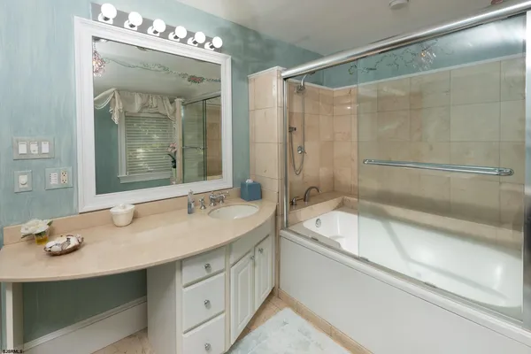 a bathroom with a tub sink and mirror