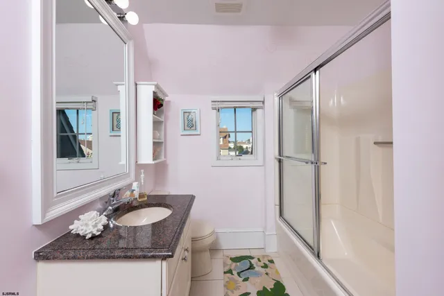 a bathroom with a granite countertop sink a mirror a vanity and a shower