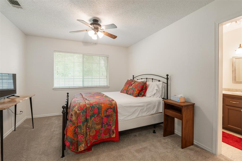 12752 Honeysuckle Circle Eustace, TX 75124 - Photo 17 of 28 Primary Bedroom featuring light carpet, multiple windows, a textured ceiling, ensuite bathroom, and a ceiling fan