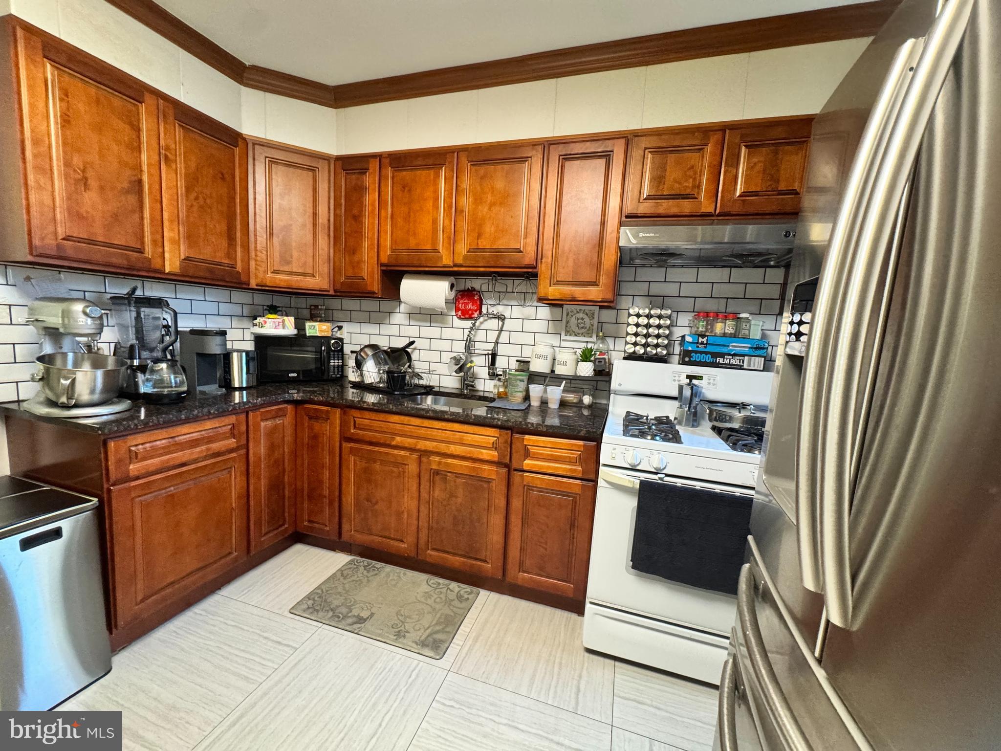 3322 Wellington Street Philadelphia, PA 19149 - Photo 3 of 18 a kitchen with stainless steel appliances granite countertop a refrigerator sink and cabinets