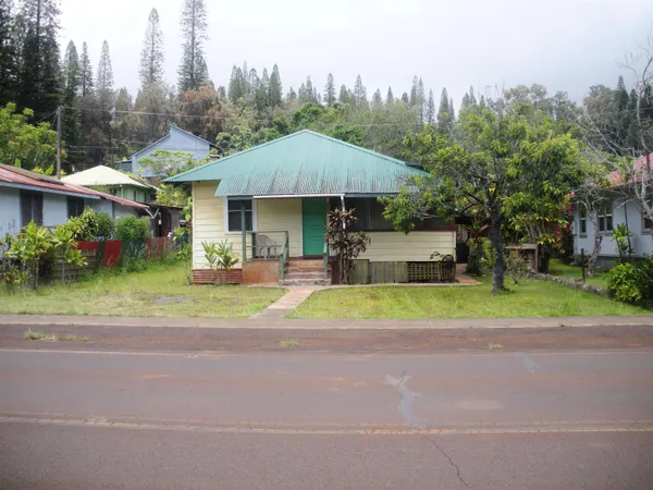 a house view with a garden space and trees