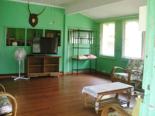 a living room with furniture a flat screen tv and floor to ceiling window