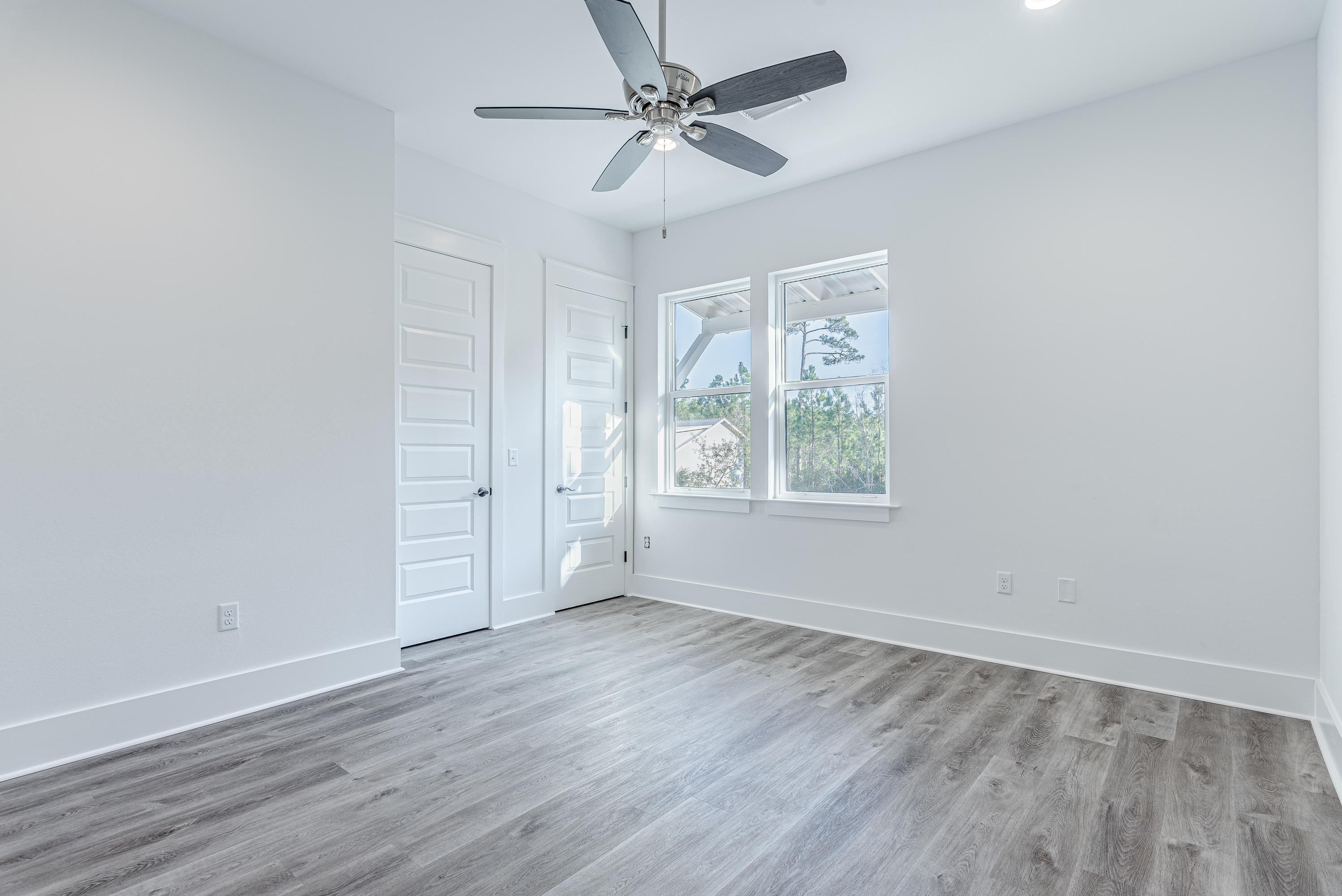 143 Marlberry Santa Rosa Beach Santa Rosa Beach, FL 32459 - Photo 44 of 53 an empty room with wooden floor chandelier fan and windows