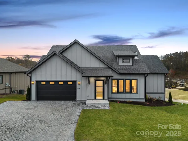 a front view of a house with a garden and yard