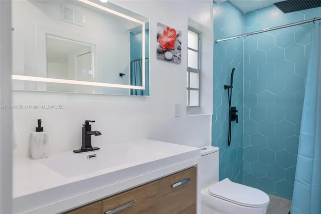 a bathroom with a sink vanity mirror and toilet