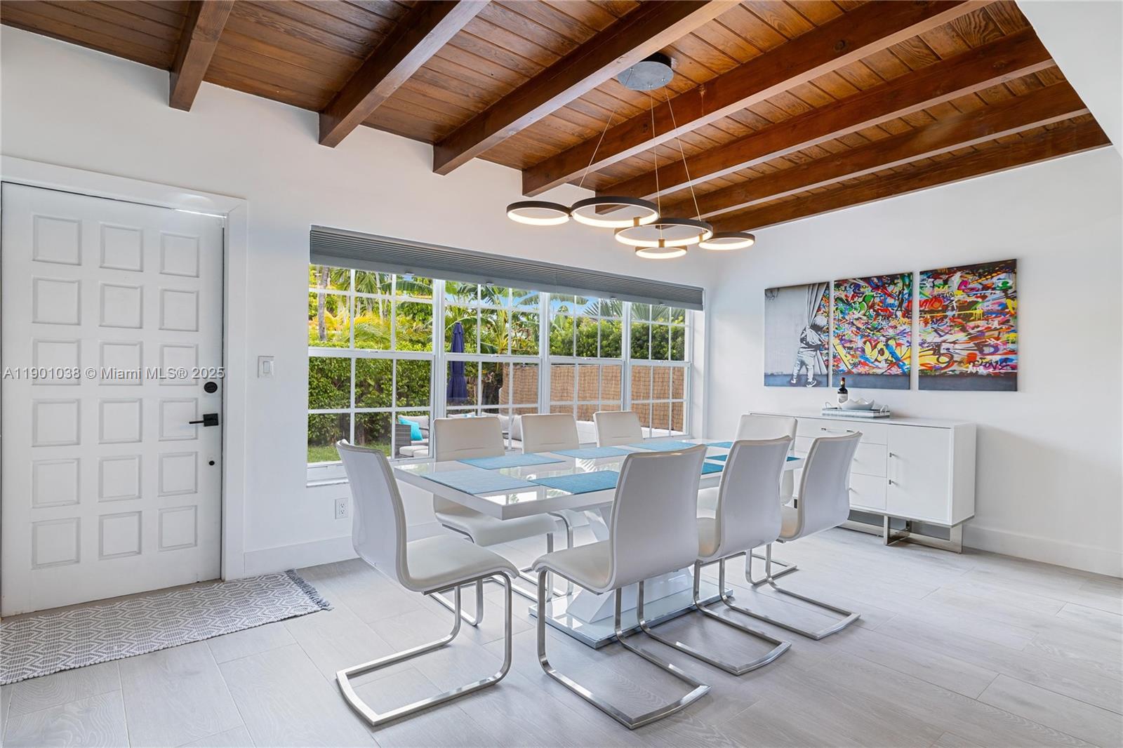 8926 Abbott Avenue Surfside, FL 33154 - Photo 2 of 30 a view of a dining room with furniture a chandelier and wooden floor