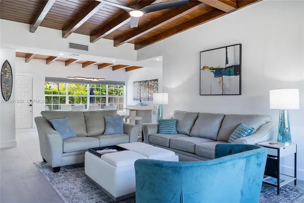 a living room with furniture a flat screen tv and a large window