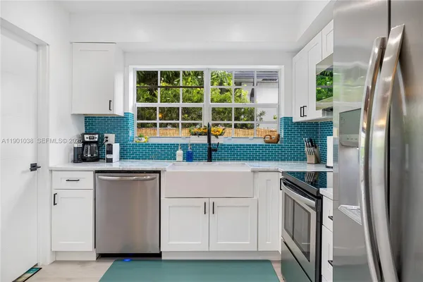 a kitchen with white cabinets and a refrigerator