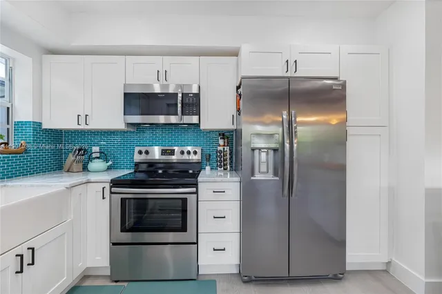 a kitchen with cabinets stainless steel appliances and a counter space