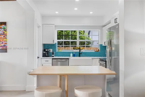 a kitchen with a table chairs refrigerator and cabinets