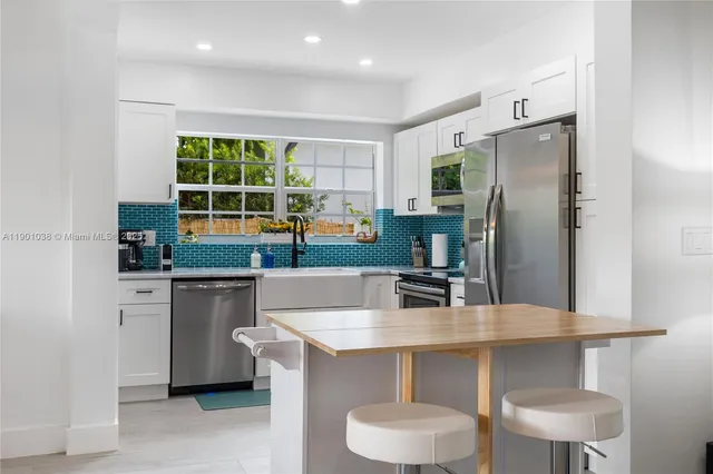 a kitchen with a table chairs refrigerator and cabinets