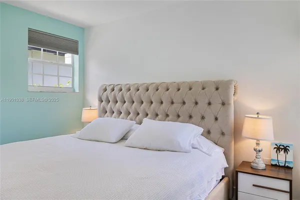 a bedroom with a bed and a painting on the wall