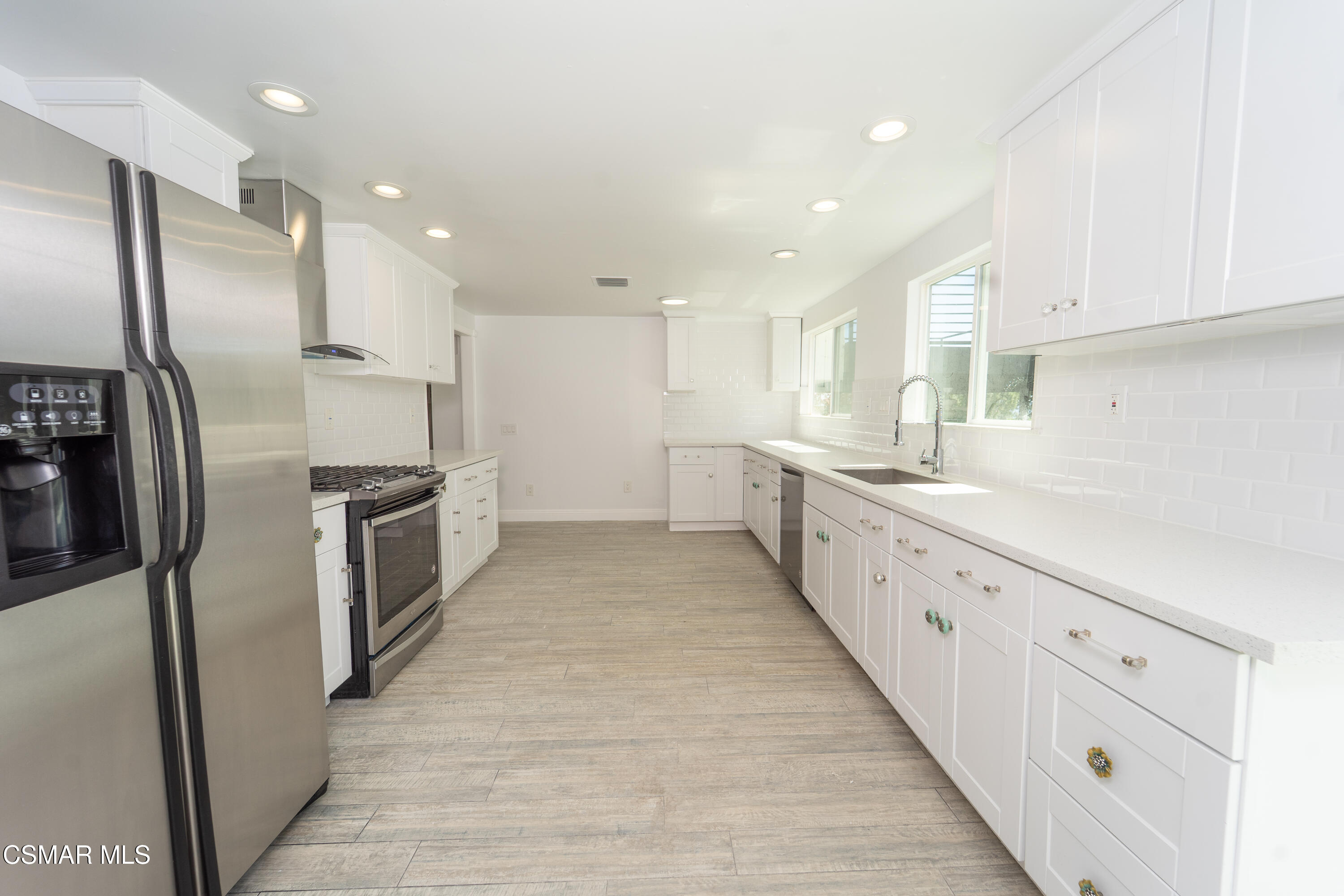 11723 Porter Valley Drive Porter Ranch, CA 91326 - Photo 16 of 64 a large kitchen with stainless steel appliances lots of counter top space sink refrigerator and cabinets