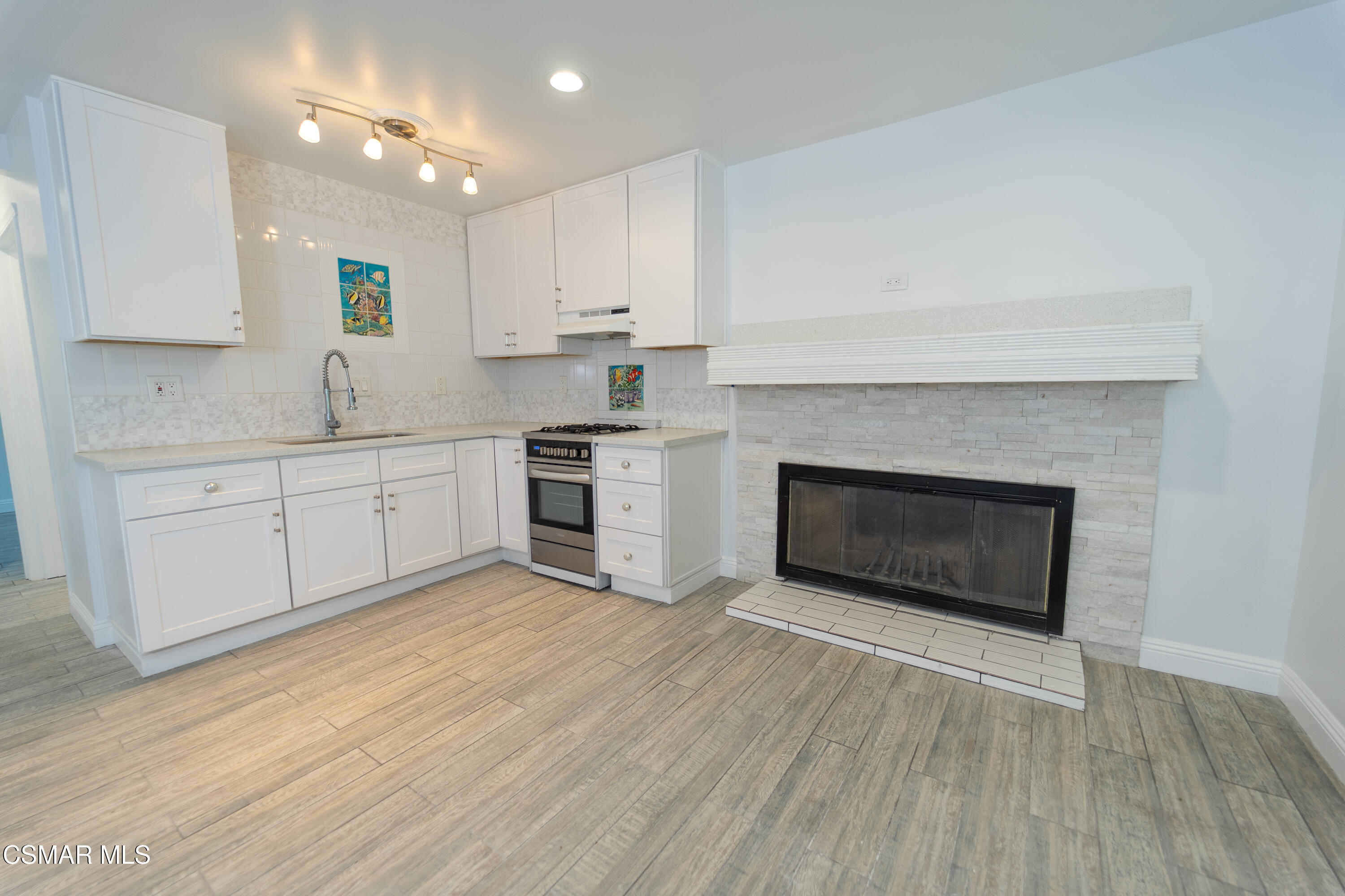 11723 Porter Valley Drive Porter Ranch, CA 91326 - Photo 21 of 64 a open kitchen with cabinets a sink and a fireplace
