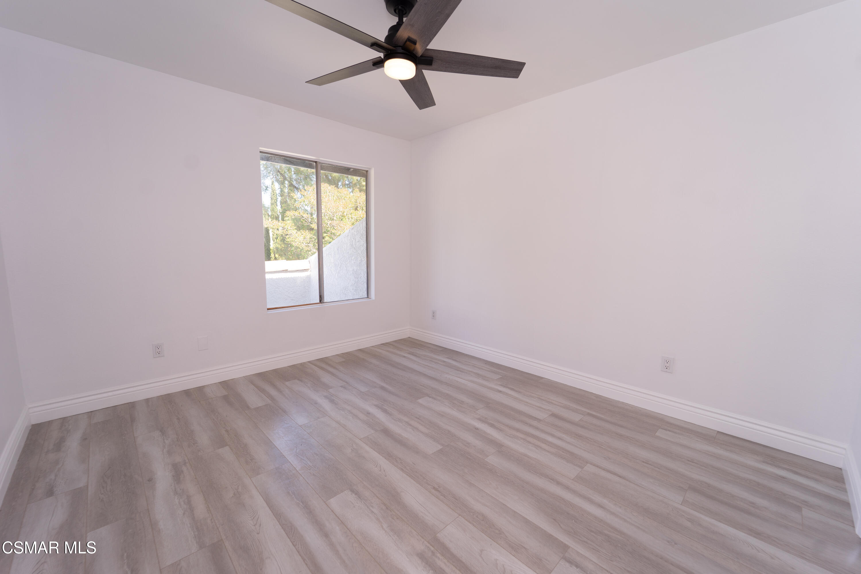 11723 Porter Valley Drive Porter Ranch, CA 91326 - Photo 41 of 64 an empty room with wooden floor fan and windows