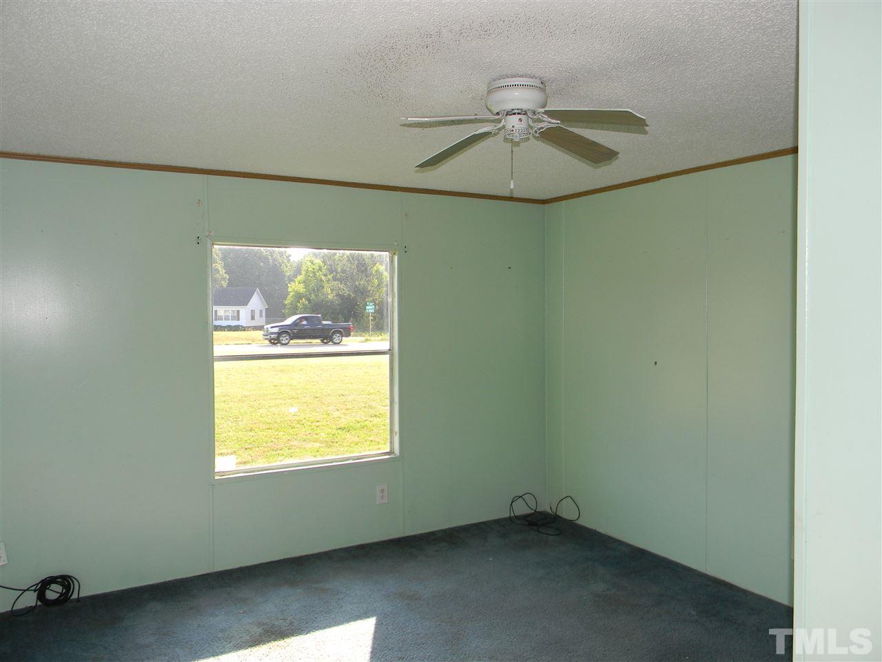 6899 Driver Road Zebulon, NC 27597 - Photo 11 of 16 an empty room with a window and ceiling fan