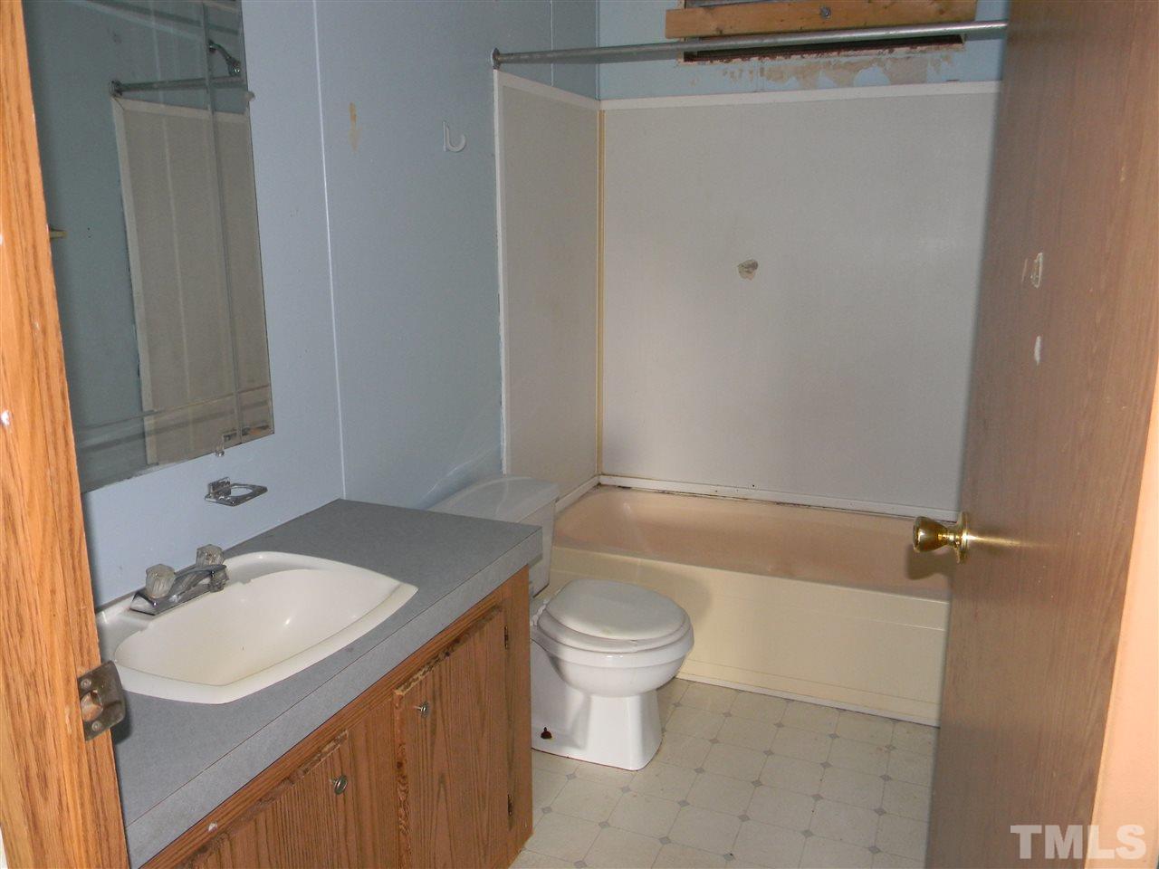 6899 Driver Road Zebulon, NC 27597 - Photo 14 of 16 a bathroom with a sink toilet vanity and shower