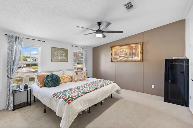 a bedroom with a bed dresser and window
