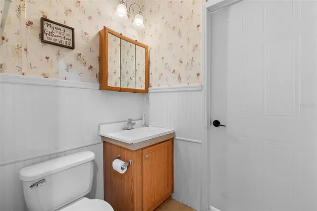 a bathroom with a toilet sink and mirror