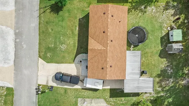 an aerial view of a house with backyard space and balcony