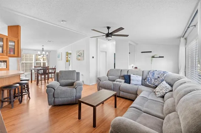 a living room with furniture wooden floor and a chandelier