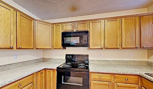 a kitchen with granite countertop cabinets stainless steel appliances and a counter space