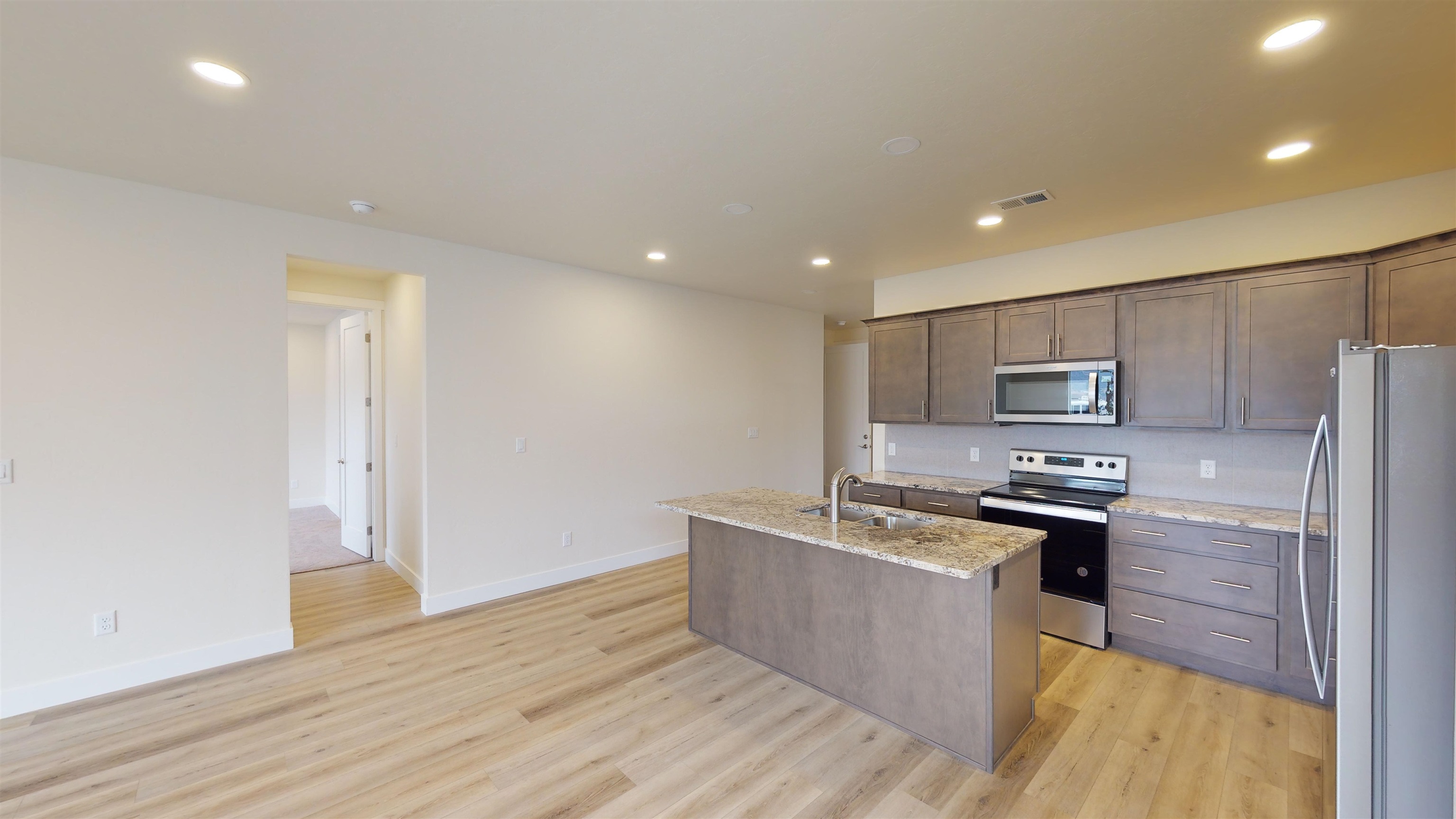 1747 Iron Drive Fruita, CO 81521 - Photo 6 of 30 a large kitchen with stainless steel appliances a large counter top a stove a refrigerator and a sink