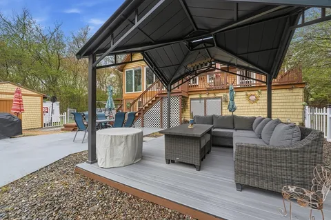a view of a house with backyard and sitting area