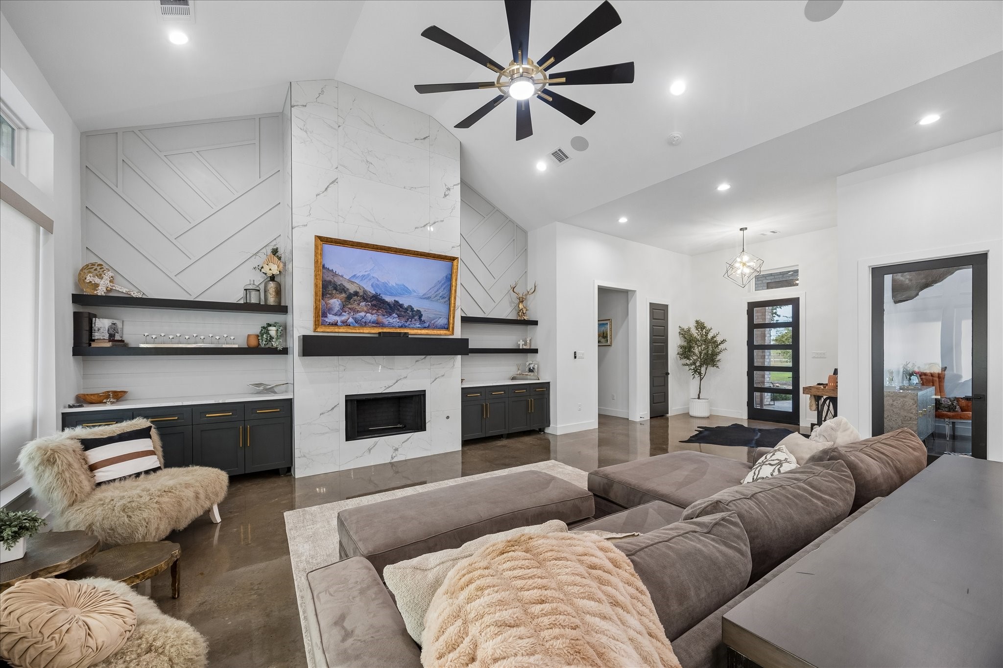 3555 Eli Road Bellville, TX 77418 - Photo 3 of 31 Soaring ceilings and a stunning floor-to-ceiling tile gas fireplace serve as the focal point of the home, framed by beautiful built-in cabinetry and open shelving for added style and storage.