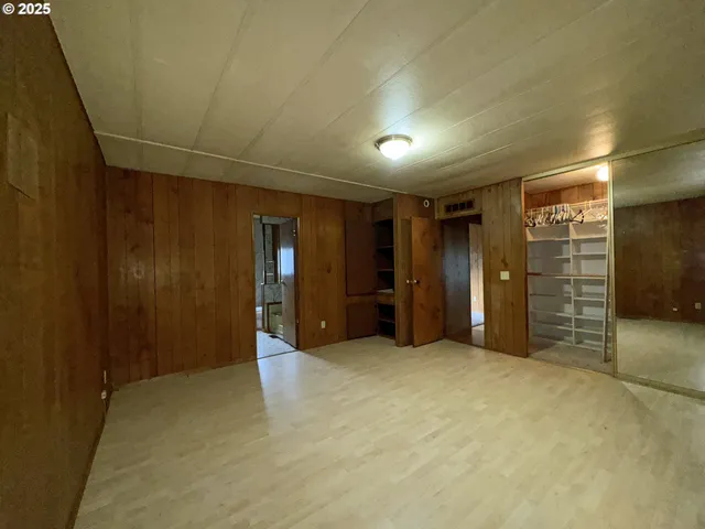 a view of an empty room and kitchen