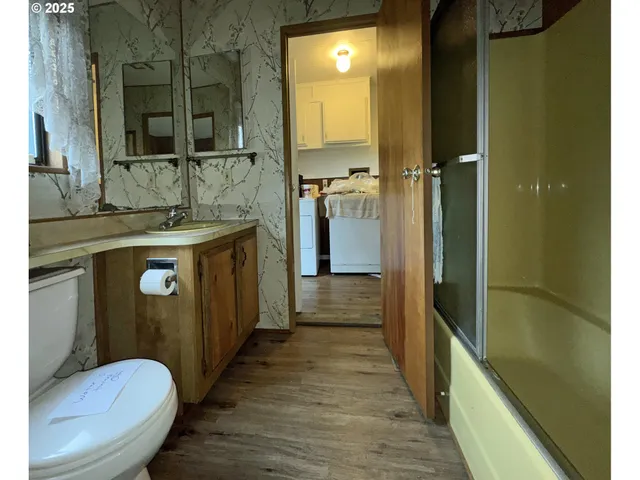 a bathroom with a granite countertop sink a toilet and shower