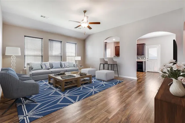 a living room with furniture and wooden floor