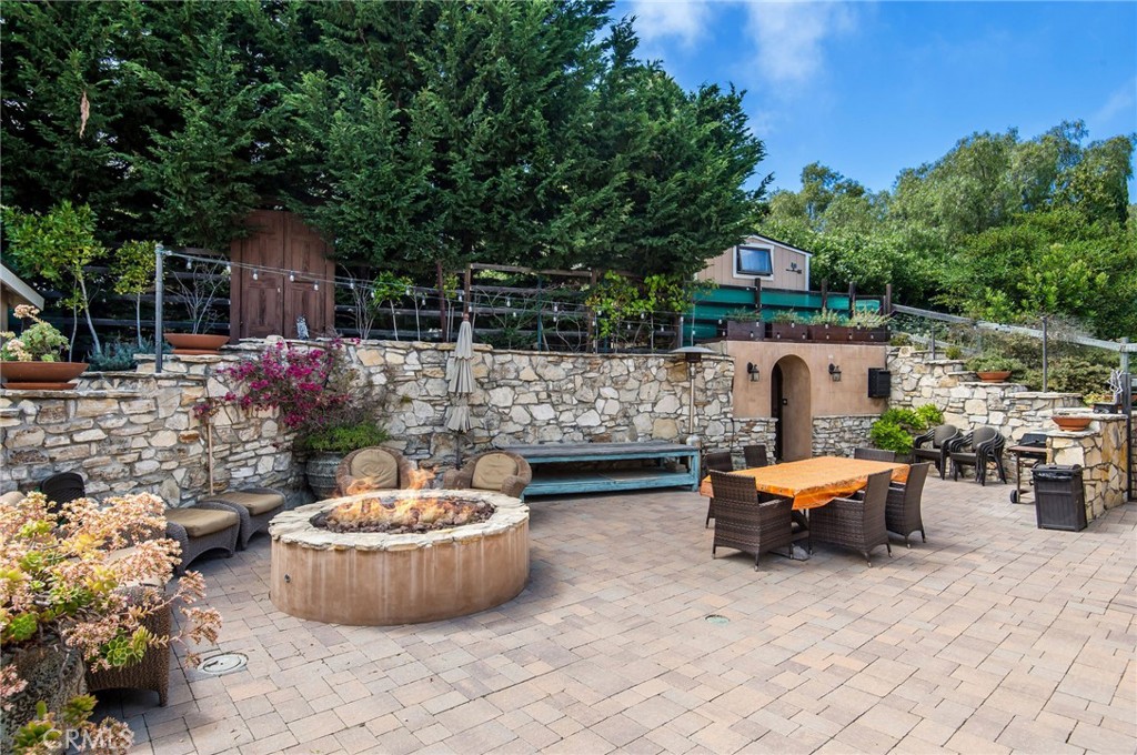 1 Thyme Place Rancho Palos Verdes, CA 90275 - Photo 9 of 35 a view of a backyard with table and chairs potted plants and a large tree