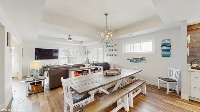 a view of a dining room with furniture a chandelier and wooden floor