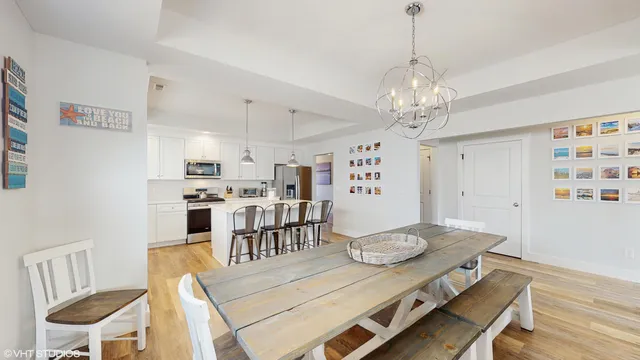 a kitchen with stainless steel appliances granite countertop a stove a sink a dining table and chairs