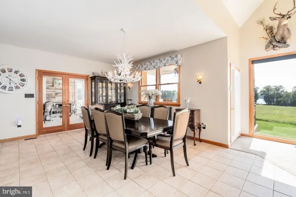 a kitchen with stainless steel appliances kitchen island granite countertop a stove a sink a dining table and chairs