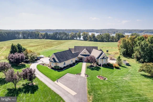 a view of a swimming pool and lounge chairs in back yard of the house