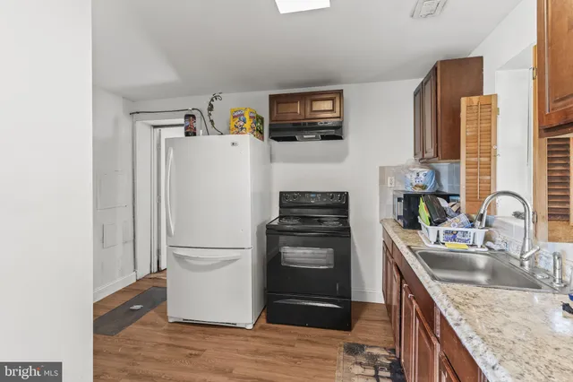 a kitchen with granite countertop a refrigerator stove and sink