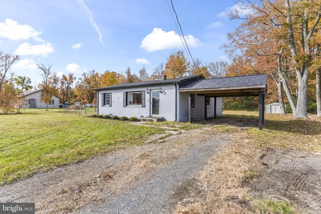 a view of a yard in front of a house with large trees
