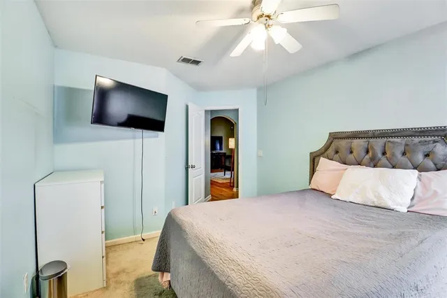 a bedroom with a large bed and a flat screen tv