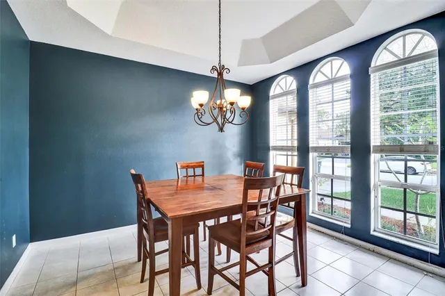 a view of a dining room with furniture a chandelier and wooden floor