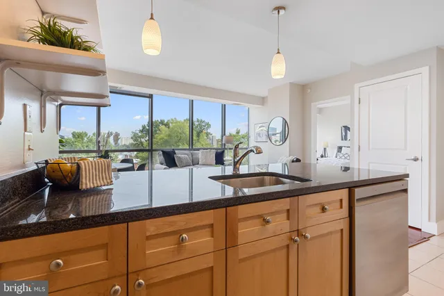 a kitchen with stainless steel appliances granite countertop a sink a stove and a wooden floors